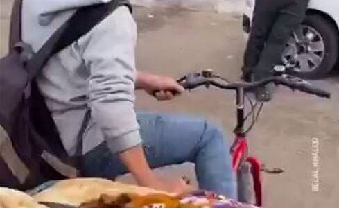 فلسطيني يضع جثمان طفله في سلة دراجة هوائية