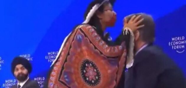مشهد غريب لزعيمة من الأمازون تنفخ على رؤوس المشاركين في جلسة في المنتدى الاقتصادي العالمي دافوس