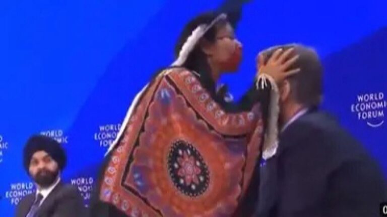 مشهد غريب لزعيمة من الأمازون تنفخ على رؤوس المشاركين في جلسة في المنتدى الاقتصادي العالمي دافوس