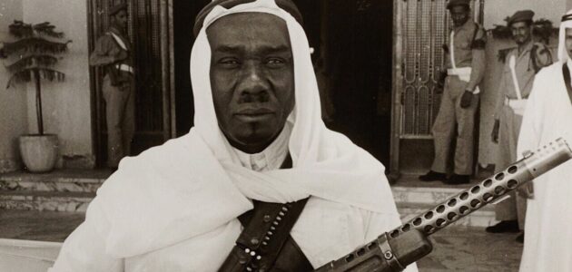 يحمل في يده بندقية.. شاهد صورة نادرة لحارس الملك فيصل بالقصر الأحمر في الرياض.. والكشف عن تاريخ التقاطها