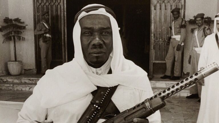 يحمل في يده بندقية.. شاهد صورة نادرة لحارس الملك فيصل بالقصر الأحمر في الرياض.. والكشف عن تاريخ التقاطها